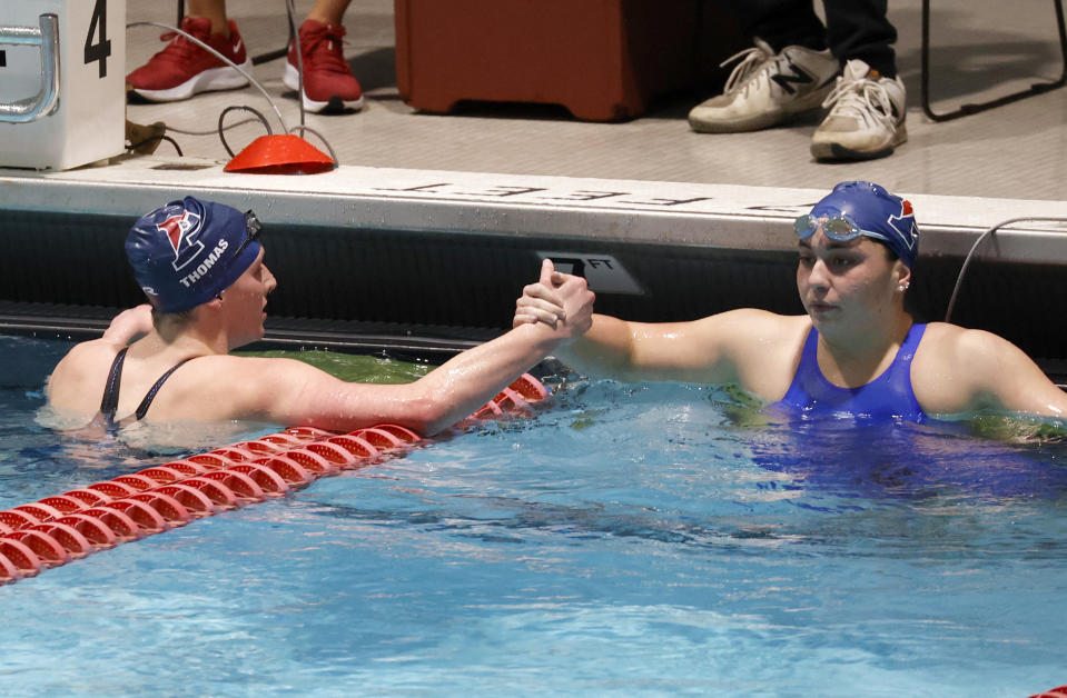 Pennsylvania's Lia Thomas, left, shakes hands with teammate Anna Sofia Kalandadze after Thomas finished first in the 500-yard freestyle final at the Ivy League women's swimming and diving championships at Harvard University, Thursday, Feb. 17, 2022, in Cambridge, Mass. Thomas, who is transitioning to female, is swimming for the Penn women's team. (AP Photo/Mary Schwalm)