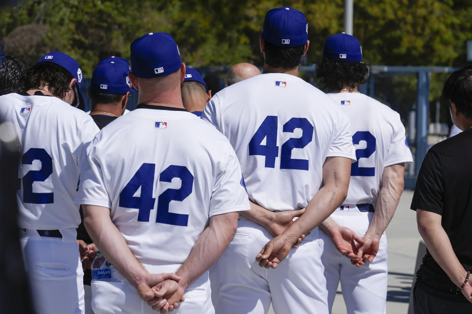 Los Angeles Dodgers pitchers Shohei Ohtani, center right, joins team members to celebrate Jackie Robinson Day before a baseball game against the Washington Nationals at Dodgers Stadium in Los Angeles on Monday, April 15, 2024. (AP Photo/Damian Dovarganes)