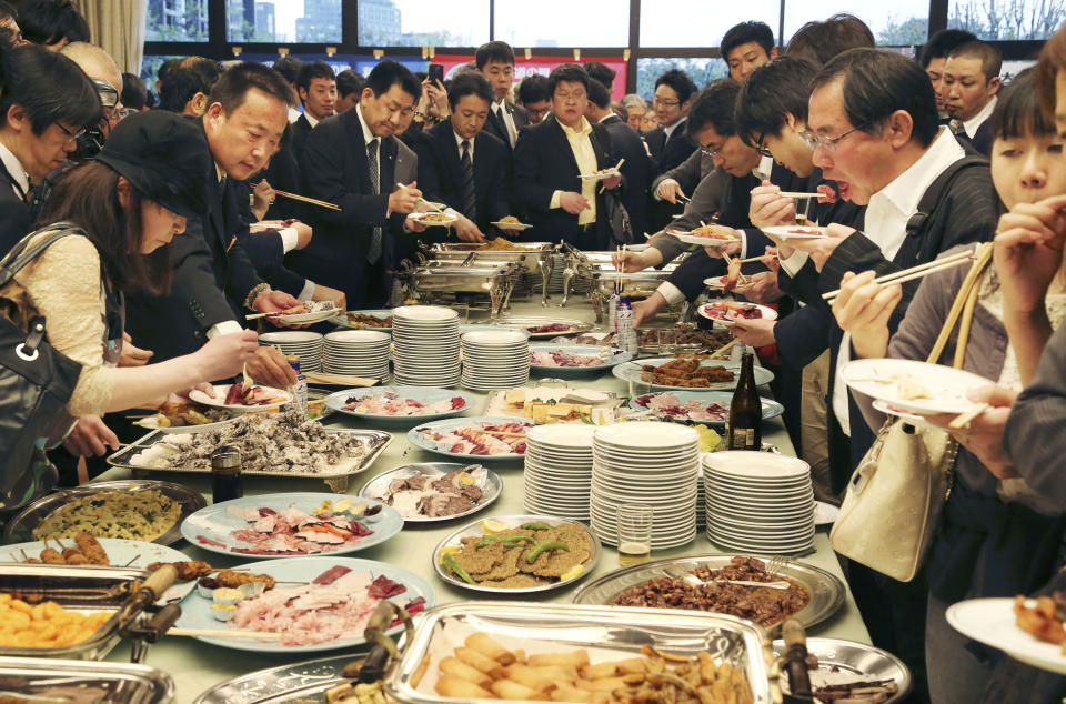 Supporters of Japan's whaling eat whale meat dishes during the 26th whale meat tasting event in Tokyo Tuesday, April 15, 2014. Hundreds of Japanese pro-whaling officials, lawmakers and lobby groups vowed to protect whale hunts despite the world court ruling that ordered the country’s Antarctic research culls must be stopped. (AP Photo/Koji Sasahara)