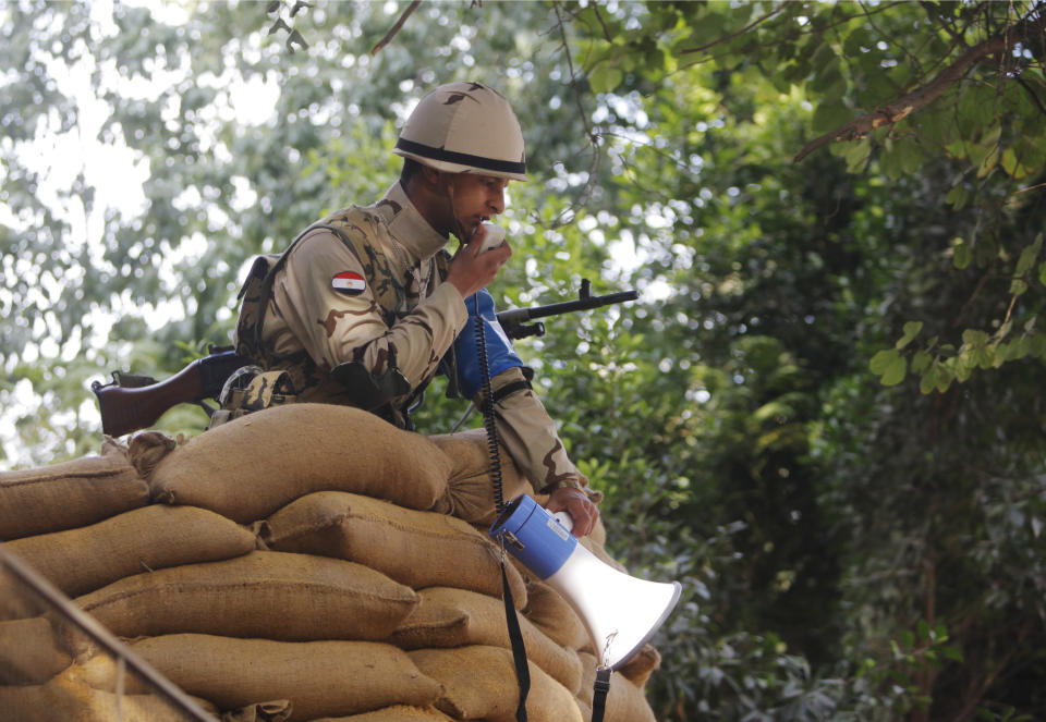 An Egyptian soldier behind a protective barrier of sand bags gives instructions to voters at a polling station in the Maadi neighborhood of Cairo, Egypt, Tuesday, Jan. 14, 2014. Egyptians are voting on a draft for their country's new constitution that represents a key milestone in a military-backed roadmap put in place after President Mohammed Morsi was overthrown in a popularly backed coup last July. (AP Photo/Amr Nabil)