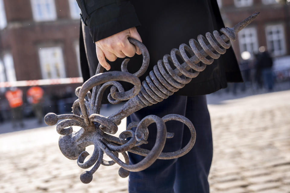 Danish Business' CEO Brian Mikkelsen holds the top of the burnt dragon spire in front of Boersen, The Stock Exchange building in Copenhagen Wednesday, April 17, 2024. A fire raged through one of Copenhagen’s oldest buildings on Tuesday, causing the collapse of the iconic spire of the 17th-century Old Stock Exchange as passersby rushed to help emergency services save priceless paintings and other valuables. (Ida Marie Odgaard/Ritzau Scanpix)