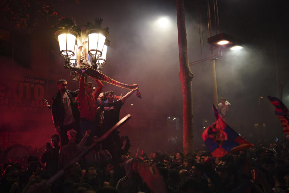 Barcelona fans celebrate in the street after their team won the Spanish La Liga championship by beating crosstown rivals Espanyol in Barcelona, Spain, Sunday May 14, 2023. (AP Photo/Joan Mateu Parra)