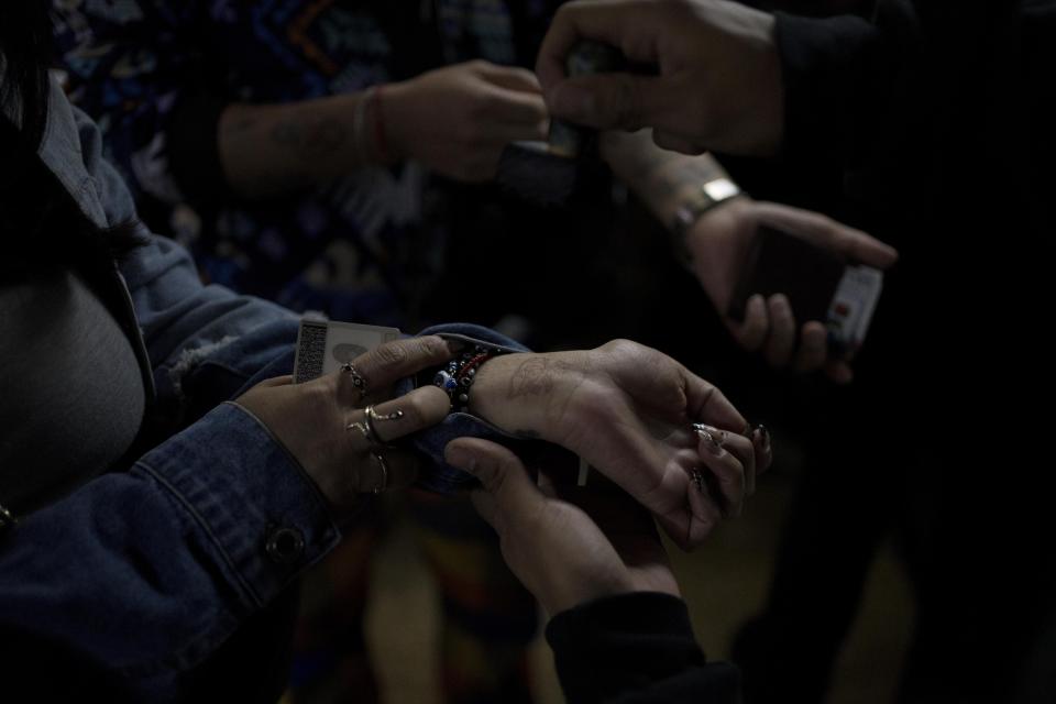 An assistant stamps the wrists of those who attended the performance by Sonido Gallo Negro, during one of the last active weekends at the iconic counterculture venue Multiforo Alicia in Mexico City, Friday, Feb. 24, 2023. The owner and founder of Alicia Ignacio Pineda said one of the main reasons he chose to close is because he doesn’t like how the neighborhood around the venue has changed. (AP Photo/Eduardo Verdugo)