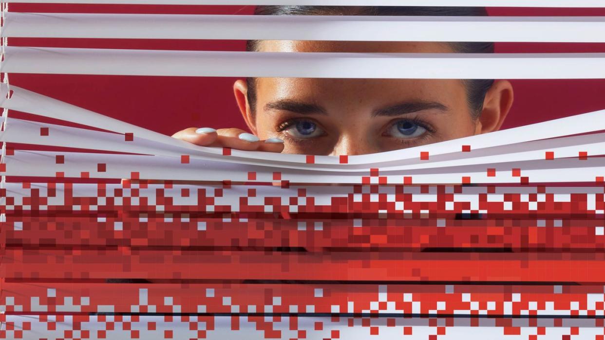 woman looking out of blinds