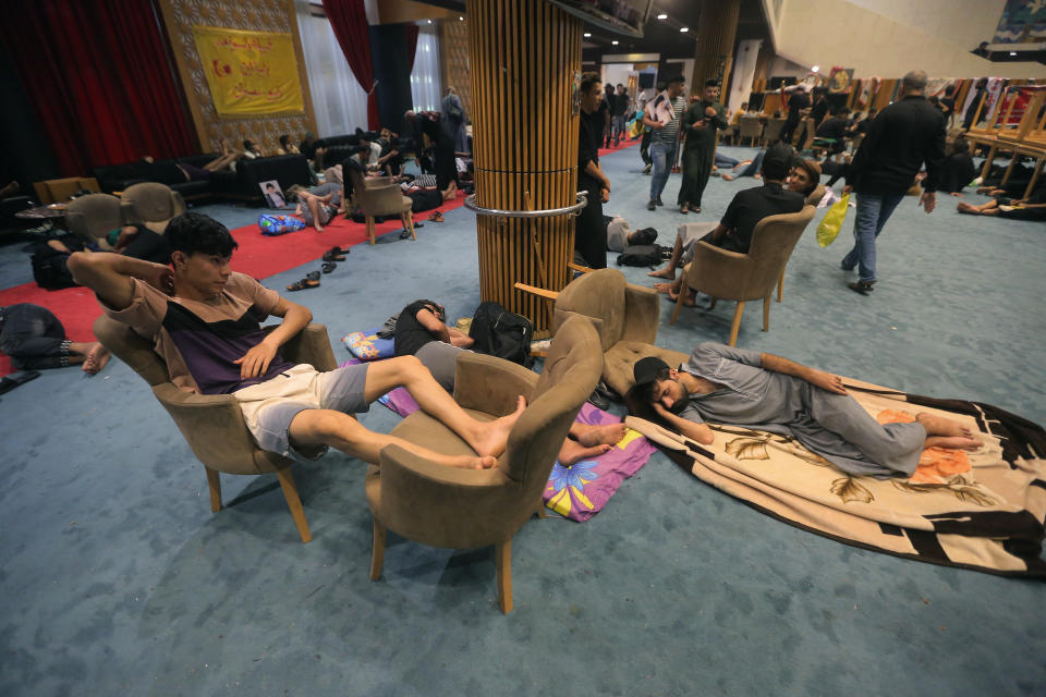 Followers of Shiite cleric Moqtada al-Sadr rest in the parliament building during a sit-in protest, in Baghdad, Iraq, Wednesday, Aug. 3, 2022. The Influential Shiite cleric has told his followers to continue their sit-in inside Iraq's government zone, and called for the dissolution of the parliament and early elections. (AP Photo/Anmar Khalil)