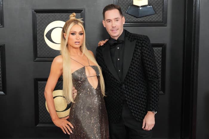 The couple stand with their arms around each other as they pose on the Grammys red carpet