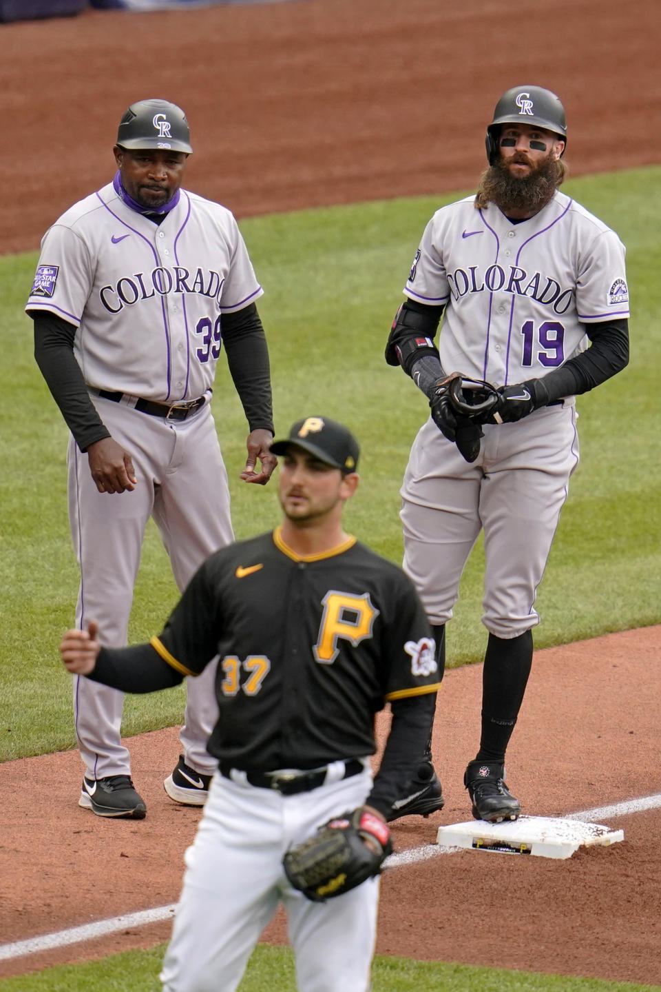 Colorado Rockies' Charlie Blackmon (19) stand next to third base coach Stu Cole (39) on third after hitting a triple off Pittsburgh Pirates starting pitcher Chase De Jong (37), driving in a run, during the fourth inning of a baseball game in Pittsburgh, Sunday, May 30, 2021. (AP Photo/Gene J. Puskar)