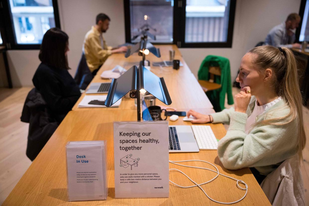 People work at shared workspaces at the WeWork, coworking and office space in the City of London. Photo: Tolga Akmen/AFP via Getty Images