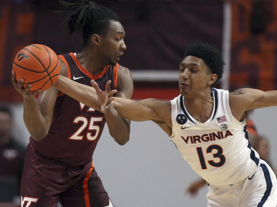 Virginia Tech's Justyn Mutts (25) has the ball tipped from him by Virginia's Ryan Dunn (13) in the first half of an NCAA college basketball game in Blacksburg Va., Saturday, Feb. 4, 2023. (Matt Gentry/The Roanoke Times via AP)