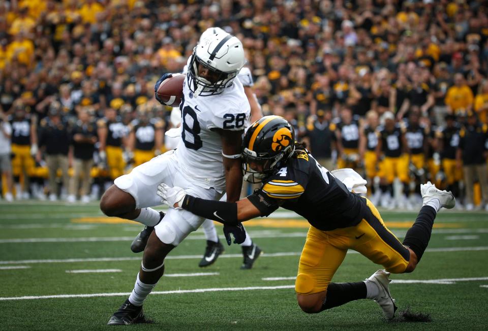 Penn State running back Devyn Ford tries to avoid the tackle of Iowa defensive back Dane Belton during the first quarter at Kinnick Stadium in Iowa City, Iowa.