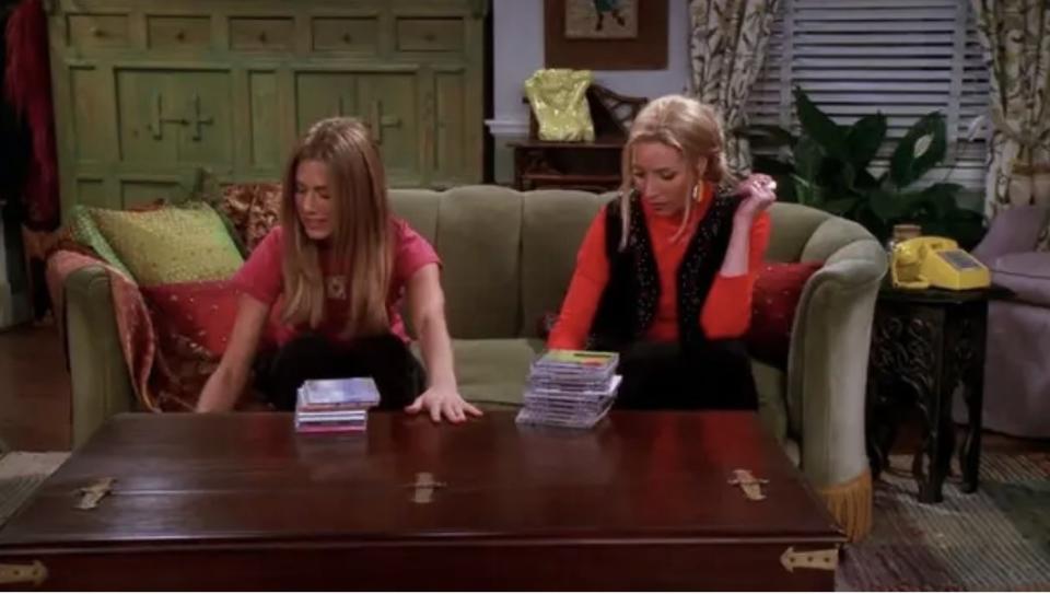 Rachel and Phoebe sitting on a couch with CDs in front of them on a table