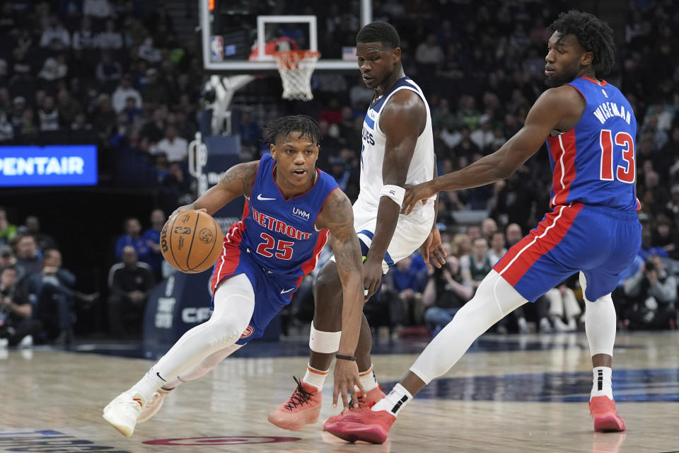 Detroit Pistons guard Marcus Sasser (25) works toward the basket as Minnesota Timberwolves guard Anthony Edwards, center, defends during the first half of an NBA basketball game, Wednesday, March 27, 2024, in Minneapolis. (AP Photo/Abbie Parr)