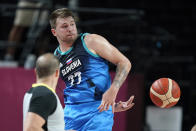 Slovenia's Luka Doncic saves the ball from going out of bounds during a men's basketball preliminary round game against Spain at the 2020 Summer Olympics, Sunday, Aug. 1, 2021, in Saitama, Japan. (AP Photo/Charlie Neibergall)