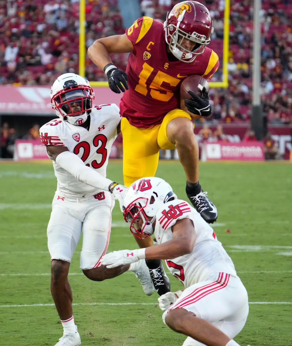 Moorpark High graduate Drake London leaps over Utah's Kamo'i Latu after getting past Faybian Marks (23) to score a USC touchdown on Saturday, Oct. 9, 2021, at the Coliseum. The Trojans lost 42-26.