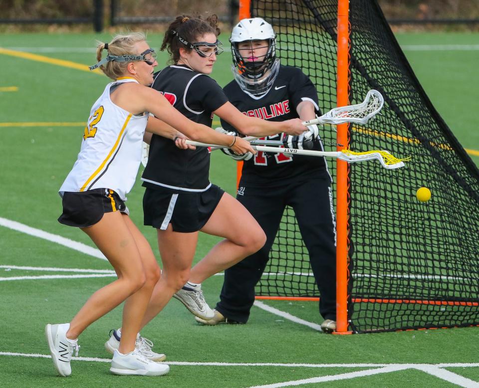 Tatnall's Ivy Qualls moves to the net against Ursuline's Claire Fowler and goalkeeper Lucy Copeland in Tatnall's 14-9 win at Tatnall School, Wednesday, March 20, 2024.