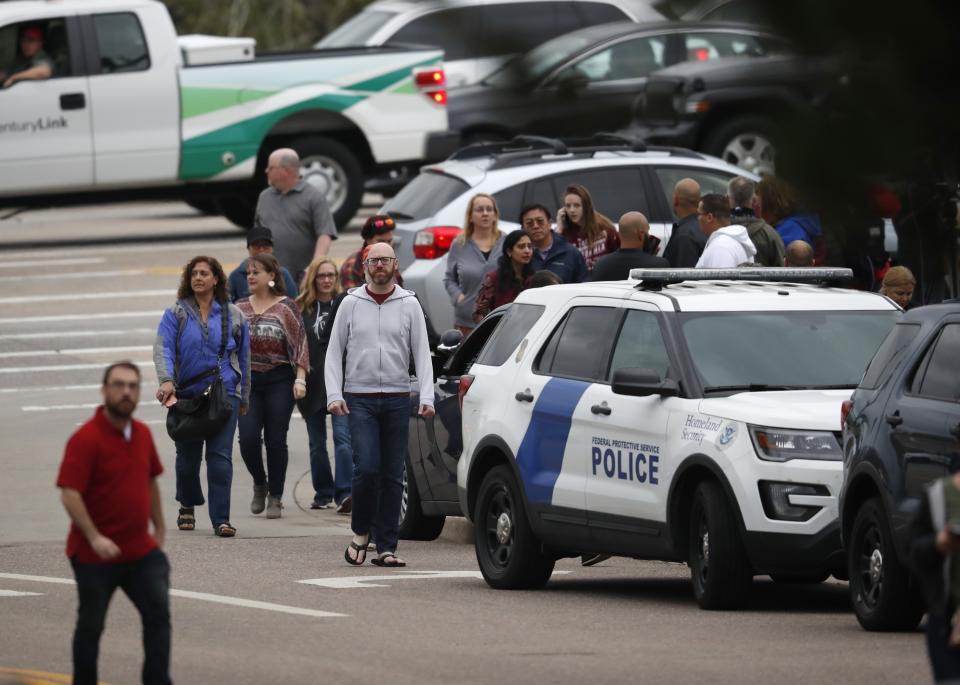 FILE - In this Tuesday, May 7, 2019 file photo, parents head into a recreation center for students to get reunited with their parents after a shooting in Highlands Ranch, Colo. Both suspects in the suburban Denver school shooting are due back in court Friday, May 10, as prosecutors file charges in the violent attack that killed a student and wounded multiple others. Authorities have identified the suspects as 18-year-old Devon Erickson and 16-year-old Maya McKinney, whose attorney said uses male pronouns and the name Alec. (AP Photo/David Zalubowski, File)