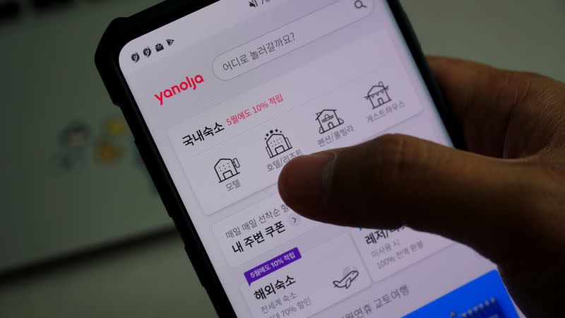 A couple looks at South Korea's accommodation-booking app on a mobile phone, in Seoul