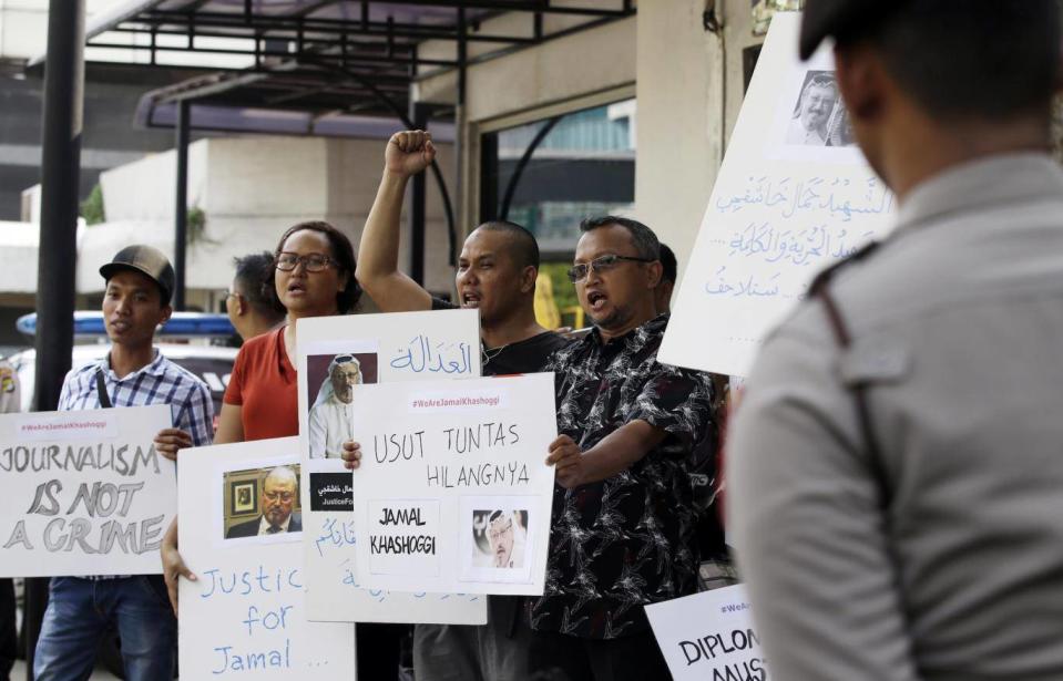 A dozen Indonesian journalists hold posters with photos of Saudi writer Jamal Khashoggi during a protest outside the Saudi embassy in Jakarta, Indonesia, on Friday ((AP Photo/Achmad Ibrahim))