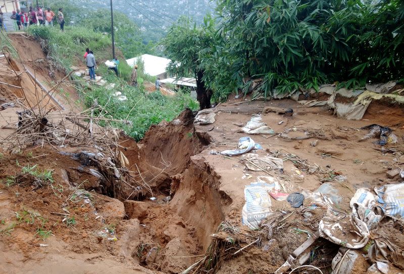 People stand watch after heavy rains caused floods and landslides, on the outskirts of Kinshasa,