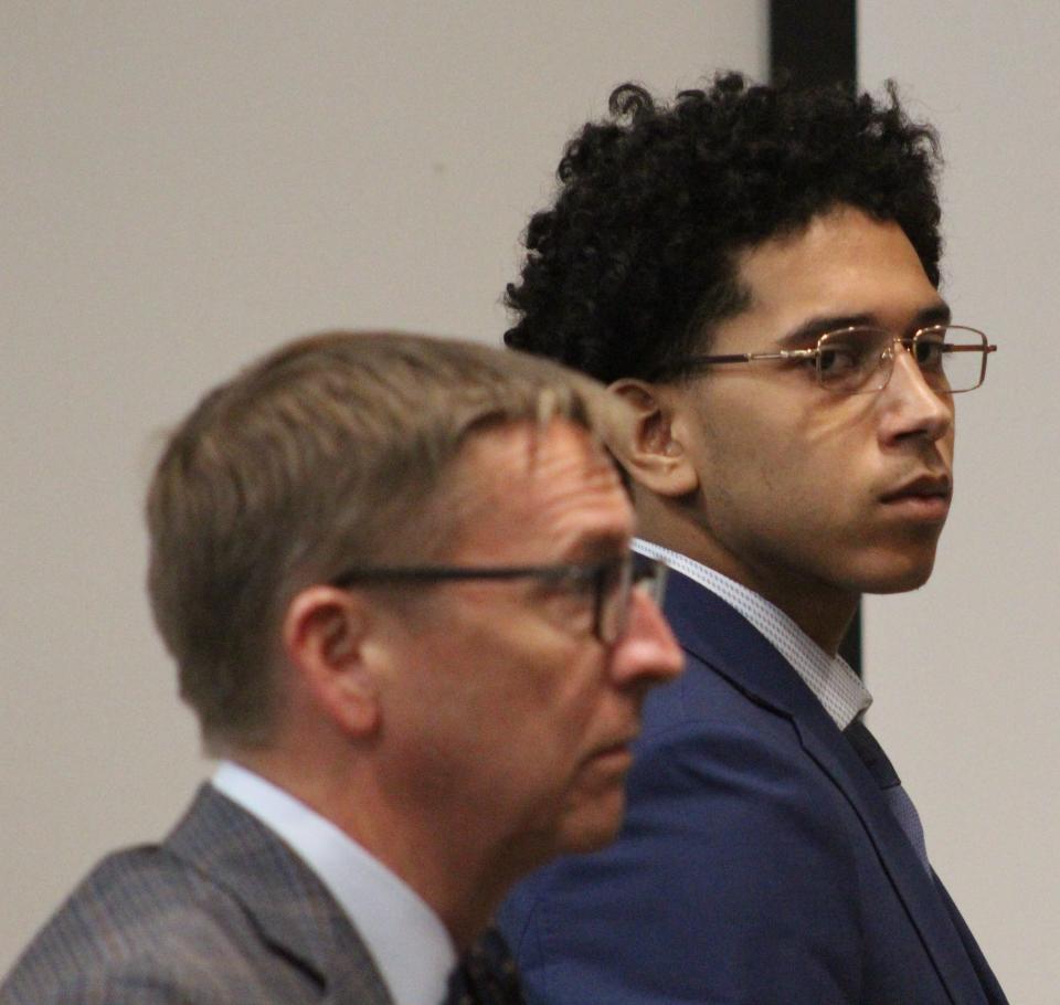 James Powell stands next to his defense attorney on Friday. Powell, 19, is charged with first-degree murder in the death of Joel Tatro of Oak Hill.
