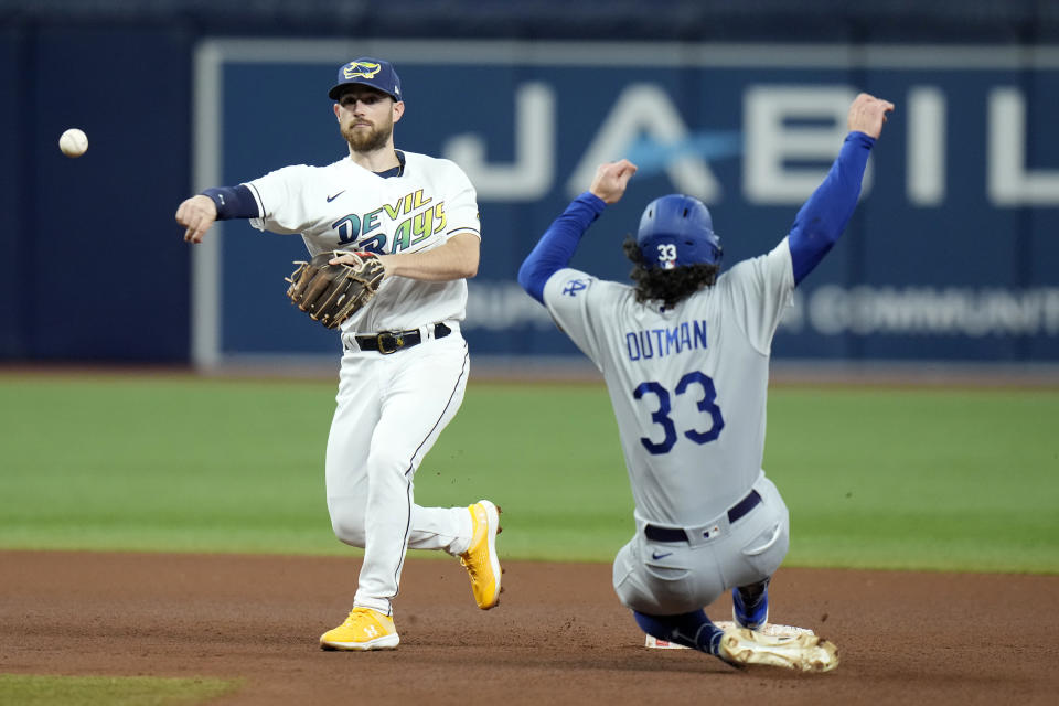 Tampa Bay Rays second baseman Brandon Lowe forces Los Angeles Dodgers' James Outman (33) at second base and turns a double play on Miguel Rojas during the fourth inning of a baseball game Friday, May 26, 2023, in St. Petersburg, Fla. (AP Photo/Chris O'Meara)