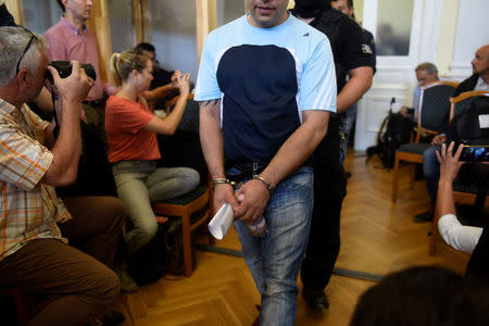 Four men, charged with the killing of 71 migrants at the height of Europe's migrant crisis in 2015, are escorted by police into a Hungarian court in Kecskemet, Hungary June 14, 2018. REUTERS/Tamas Kaszas