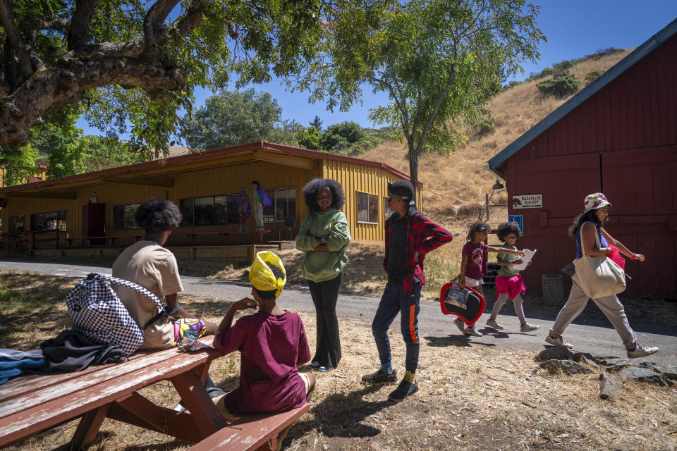 Dressed up for "Pirate Day," Ruby Beerman, 14, center, of Marin County, Calif., center, chats with Sasha Wernick, 11, of Brooklyn, before lunch at Camp Be'chol Lashon, a sleepaway camp for Jewish children of color, Friday, July 28, 2023, in Petaluma, Calif., at Walker Creek Ranch. (AP Photo/Jacquelyn Martin)