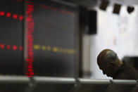 A Chinese man naps at a brokerage in Beijing, China, Tuesday, Dec. 25, 2018. Japanese stocks plunged Tuesday and other Asian markets declined following heavy Wall Street losses triggered by President Donald Trump's attack on the U.S. central bank. (AP Photo/Ng Han Guan)