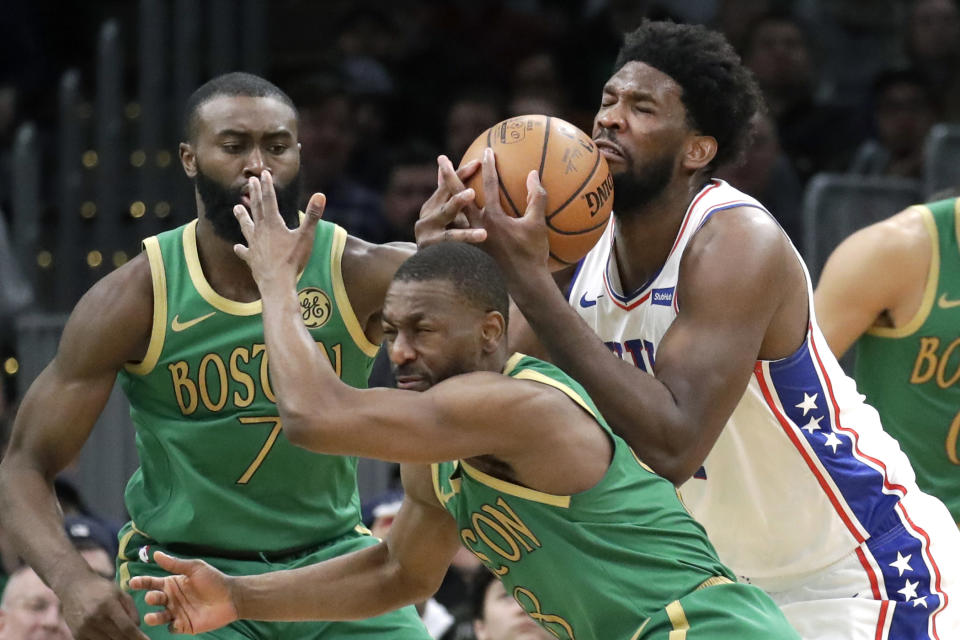 Philadelphia 76ers center Joel Embiid controls the ball against Boston Celtics guards Kemba Walker (8) and Jaylen Brown (7) in the second half of an NBA basketball game, Thursday, Dec. 12, 2019, in Boston. The 76ers won 115-109. (AP Photo/Elise Amendola)
