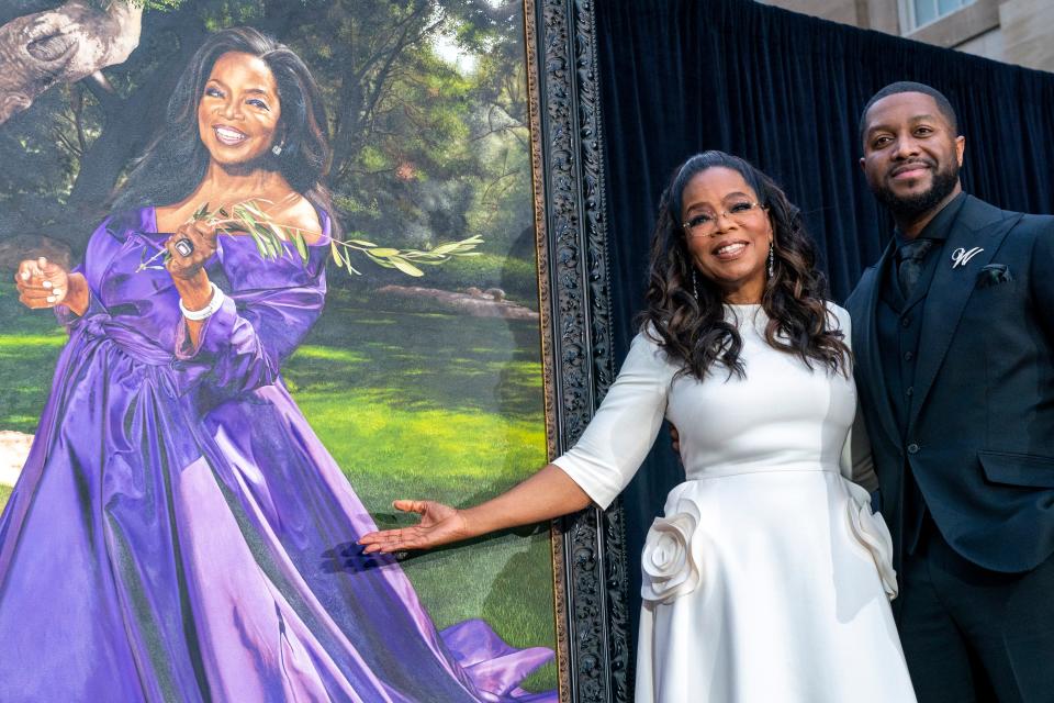 Oprah Winfrey and artist Shawn Michael Warren pose together next to Warren's portrait of Winfrey during an unveiling ceremony at the Smithsonian's National Portrait Gallery in Washington.