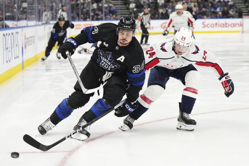 Toronto Maple Leafs forward Auston Matthews (34) and Washington Capitals forward Connor McMichael (24) race for the puck during the second period of an NHL hockey game Thursday, March 28, 2024, in Toronto. (Nathan Denette/The Canadian Press via AP)