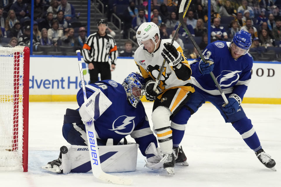 Tampa Bay Lightning goaltender Andrei Vasilevskiy (88) makes a save on a shot by Pittsburgh Penguins left wing Jake Guentzel (59) as Lightning's Darren Raddysh (43) defends during the third period of an NHL hockey game Wednesday, Dec. 6, 2023, in Tampa, Fla. (AP Photo/Chris O'Meara)