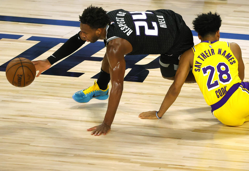 Sacramento Kings' Buddy Hield (24) grabs the ball after colliding with Los Angeles Lakers' Quinn Cook (28) during the second quarter of an NBA basketball game Thursday, Aug. 13, 2020, in Lake Buena Vista, Fla. (Kevin C. Cox/Pool Photo via AP)