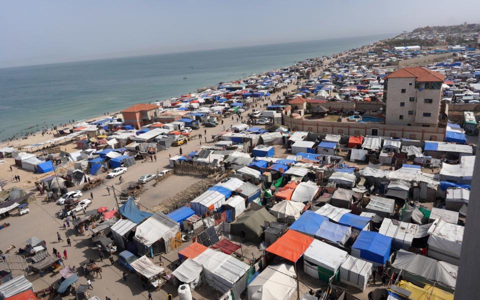 Tents housing internally displaced Palestinians crowd the beach and the Mediterranean shoreline in Deir el-Balah in the central Gaza Strip on May 10, 2024