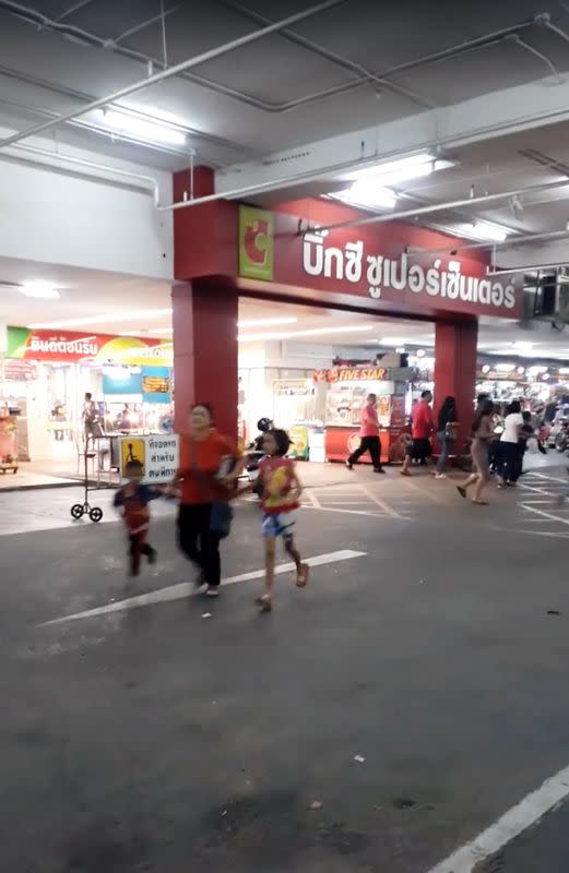 People run away from the shopping mall after a shooting rampage in the city of Nakhon Ratchasima