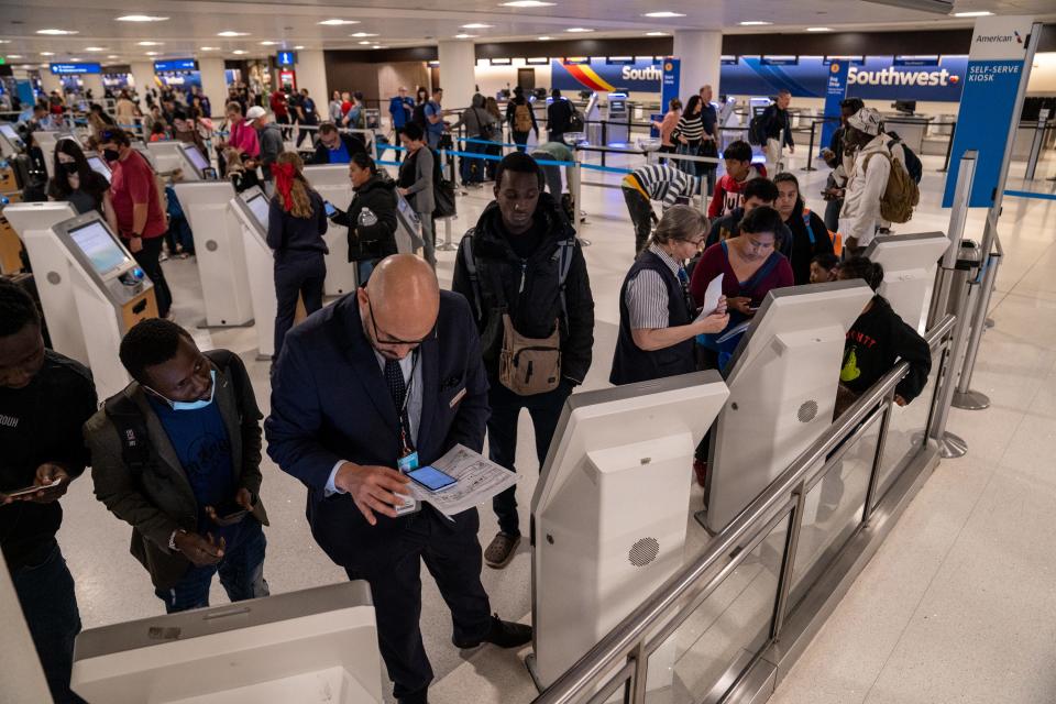 Asylum seekers check in for their flights at Terminal 4 at Phoenix Sky Harbor International Airport in Phoenix on Dec. 21, 2023.