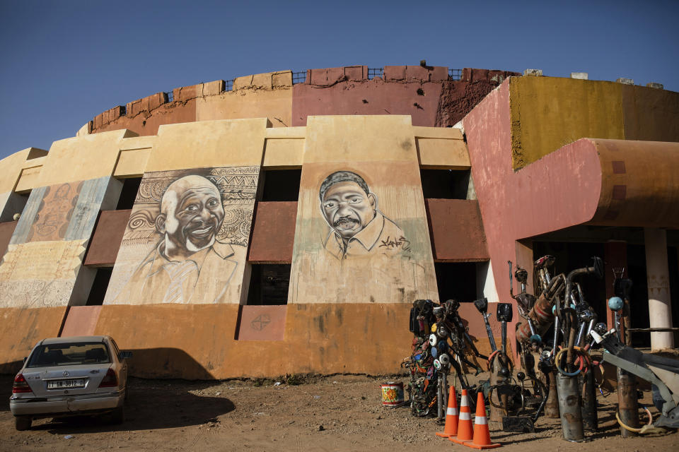 A mural depicting the Burkinabe filmmaker Idrissa Ouedraogo, center, is displayed at the headquarters of the FESPACO (Pan-African Film and Television Festival) in Ouagadougou, Burkina Faso, Wednesday, Feb. 22, 2023. Most film festivals can be counted on to provide entertainment, laced with some introspection. The weeklong FESPACO that opens Saturday in violence-torn Burkina Faso's capital goes beyond that to also offer hope, and a symbol of endurance. (AP Photo/Sophie Garcia)