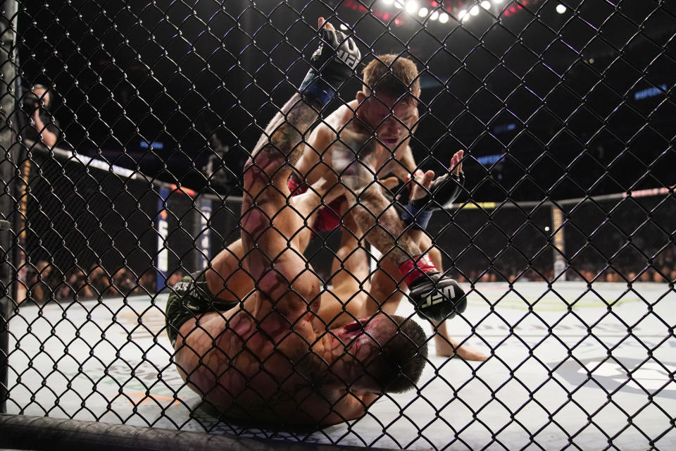 Dustin Poirier, top, punches Conor McGregor during a UFC 264 lightweight mixed martial arts bout Saturday, July 10, 2021, in Las Vegas. (AP Photo/John Locher)