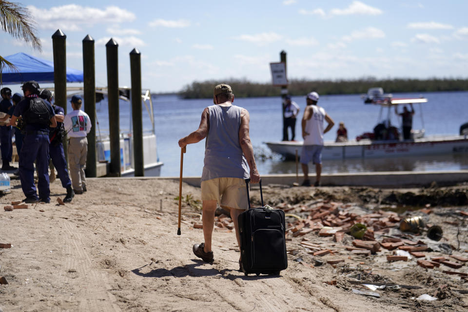 Residentes que resistieron al huracán Ian en sus casas llegan a un muelle para evacuar por vía marítima, el domingo 2 de octubre de 2022, en Pine Island, en el condado Lee, Florida. (AP Foto/Gerald Herbert)