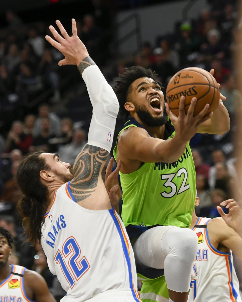 Minnesota Timberwolves center Karl-Anthony Towns (32) goes up to shoot past Oklahoma City Thunder center Steven Adams (12) during the first half of an NBA basketball game Saturday, Jan. 25, 2020, in Minneapolis. (AP Photo/Craig Lassig)