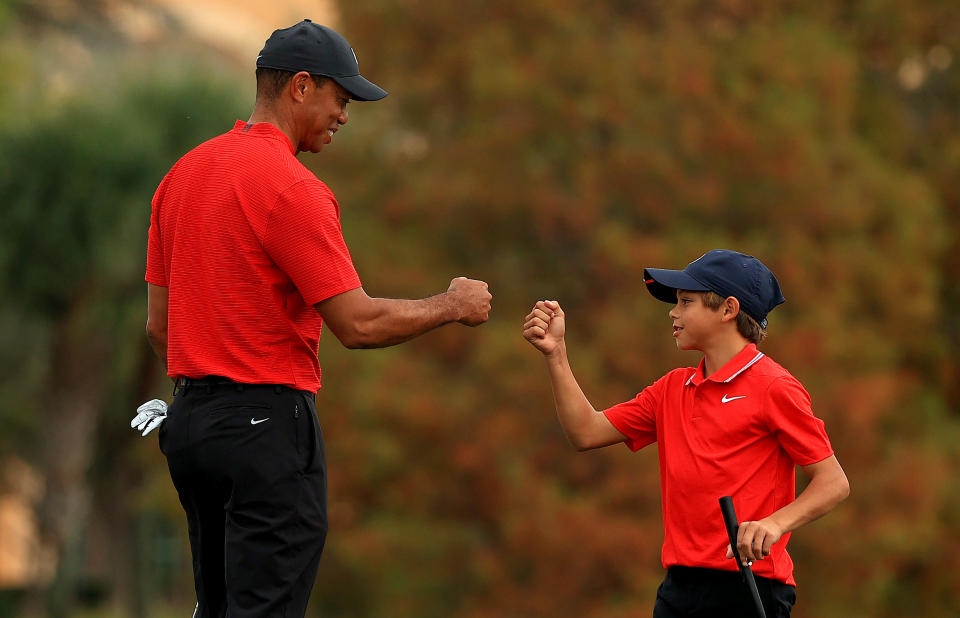 Tiger Woods of the United States and son Charlie Woods fist bump on the 18th hole during the final round of the PNC Championship at the Ritz Carlton Golf Club on December 20, 2020 in Orlando, Florida. (Photo by Mike Ehrmann/Getty Images)