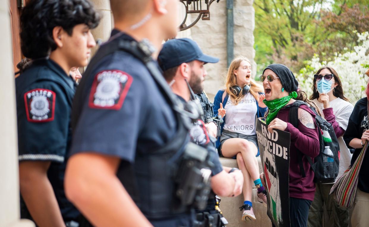 A pro-Palestine demonstrator chants at Indiana University Police Department officers at Franklin Hall on Friday, April 26, 2024.