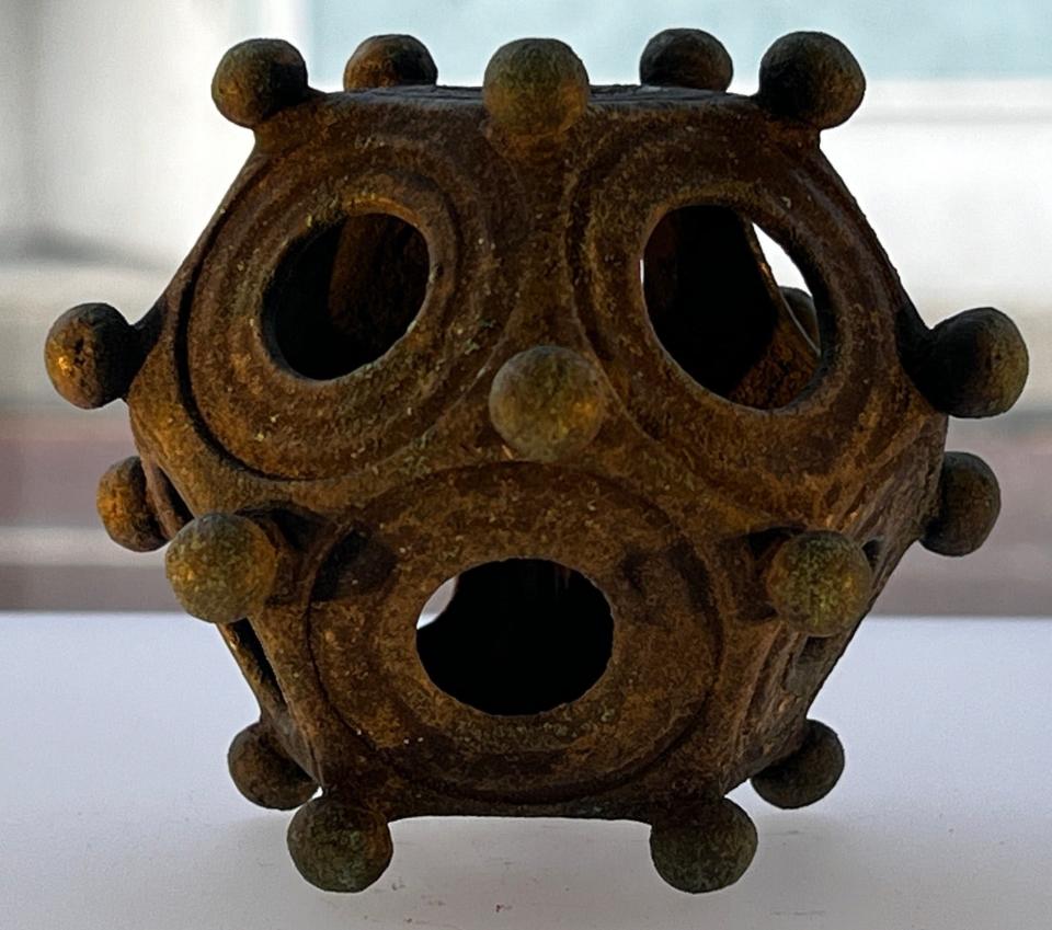 A Roman dodecahedron with holes on each of its 12 sides and knobs covering it