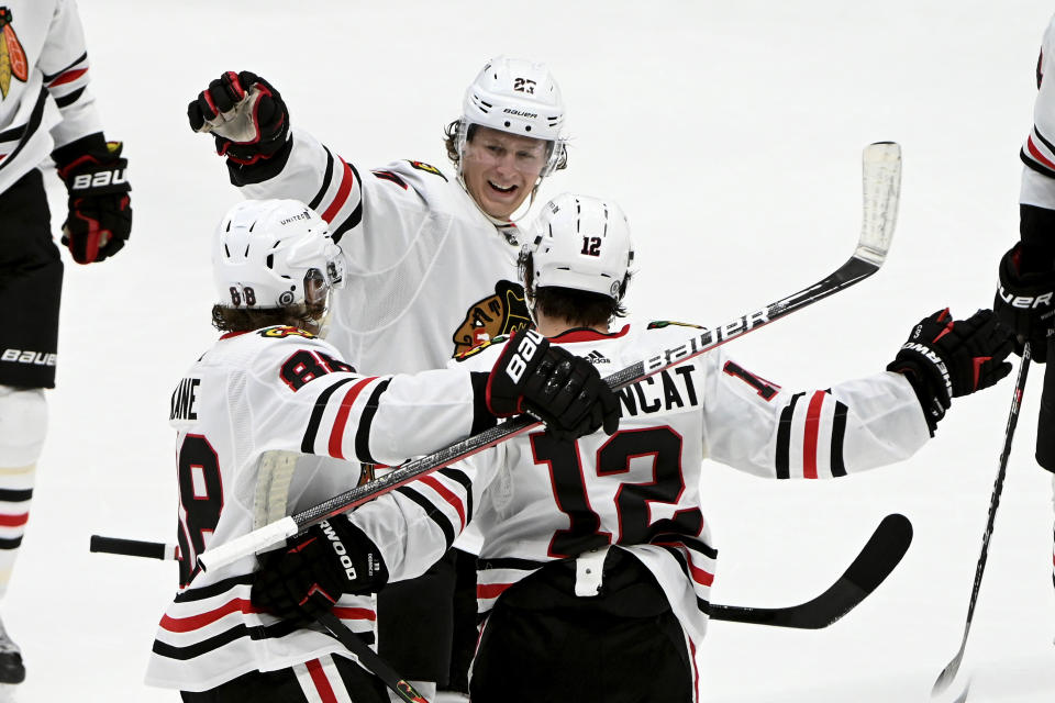 Chicago Blackhawks right wing Patrick Kane (88), defenseman Adam Boqvist (27) and left wing Alex DeBrincat (12) celebrate after DeBrincat's goal during the second period of the team's NHL hockey game against the Dallas Stars in Dallas, Thursday, March 11, 2021. (AP Photo/Matt Strasen)