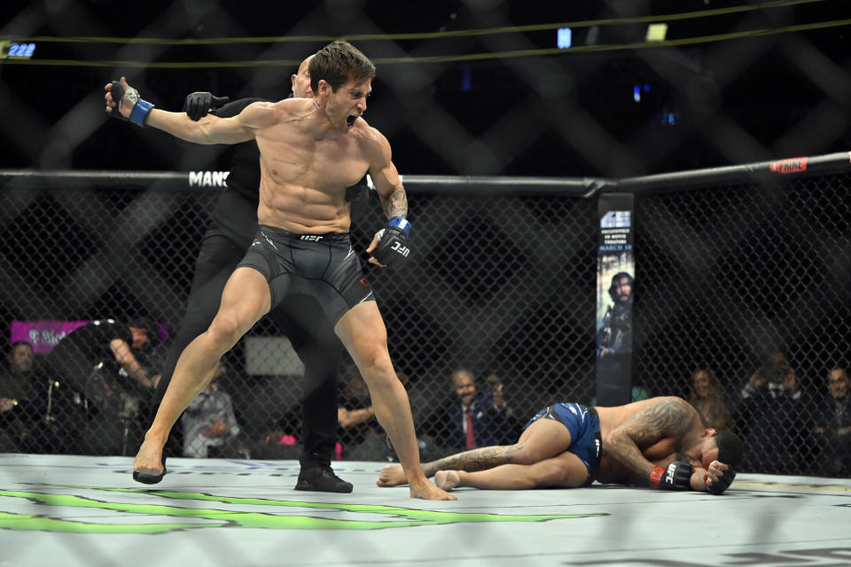 Actor Jake Gyllenhaal, left, is held back by a referee after "knocking down" actor Jay Hieron while filming a scene for an upcoming remake of the 1989 movie "Road House," during a UFC 285 mixed martial arts event Saturday, March 4, 2023, in Las Vegas. (AP Photo/David Becker)