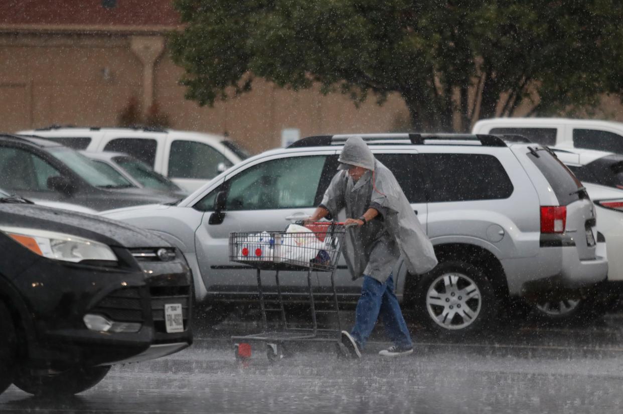 A shopper braved the rain to carry some groceries bought at the Market Street grocery store at 50th Street and Indiana Avenue, Friday, June 2, 2023.