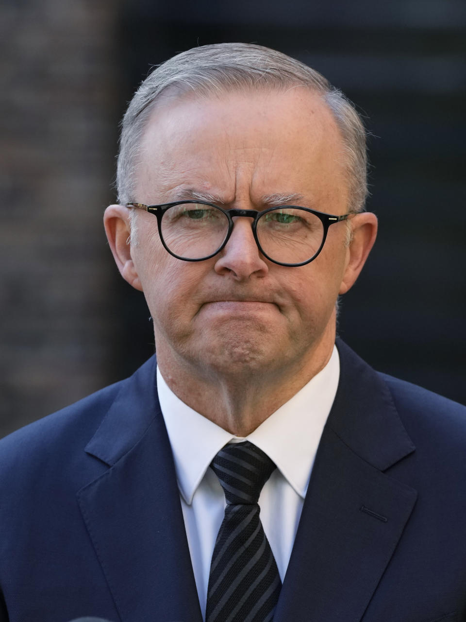 Australian Prime Minister Anthony Albanese grimaces as he answers a question about quests invited to the funeral Queen Elizabeth II in Sydney, Australia, Wednesday, Sept. 14, 2022. Albanese announced a square in honor of the late queen and that he will be taking to London the leaders of Papua New Guinea, the Solomon Islands and Tuvalu with him along with 10 ordinary people from each country to attend the funeral of Queen Elizabeth II. (AP Photo/Rick Rycroft)