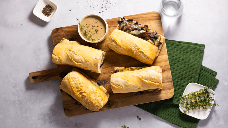 four vegetarian mushroom french dip sandwiches on wooden board