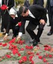 Turkish Prime Minister Ahmet Davutoglu (R) and his wife Sare Davutoglu lay red carnation flowers at the site of the double suicide bombings in Ankara, on October 13, 2015