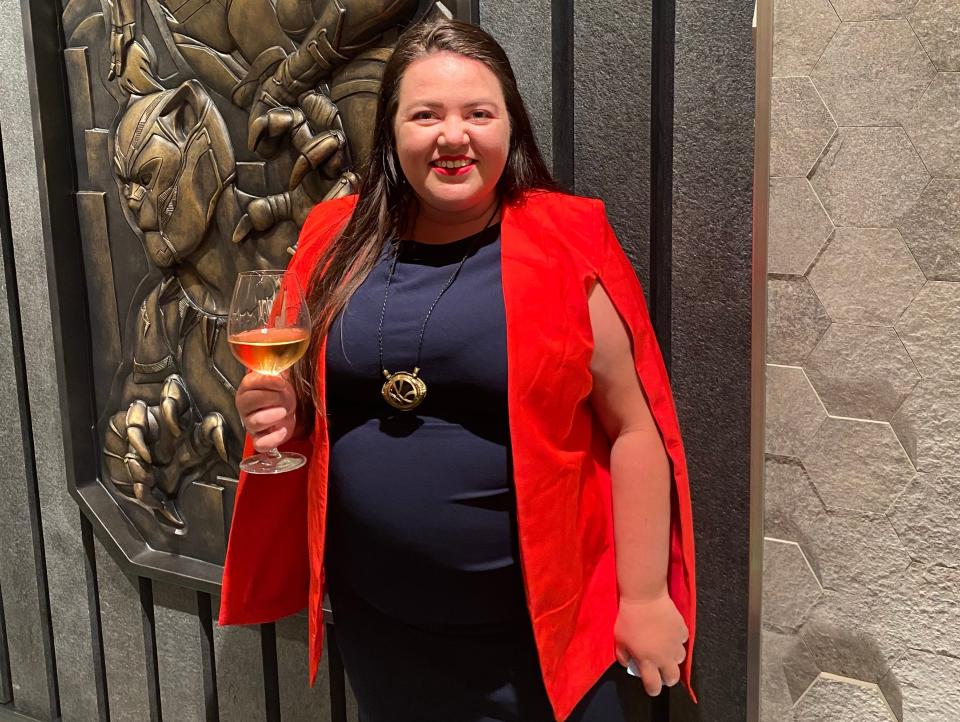 megan wearing a nice dress and holding a glass of wine on a disney cruise